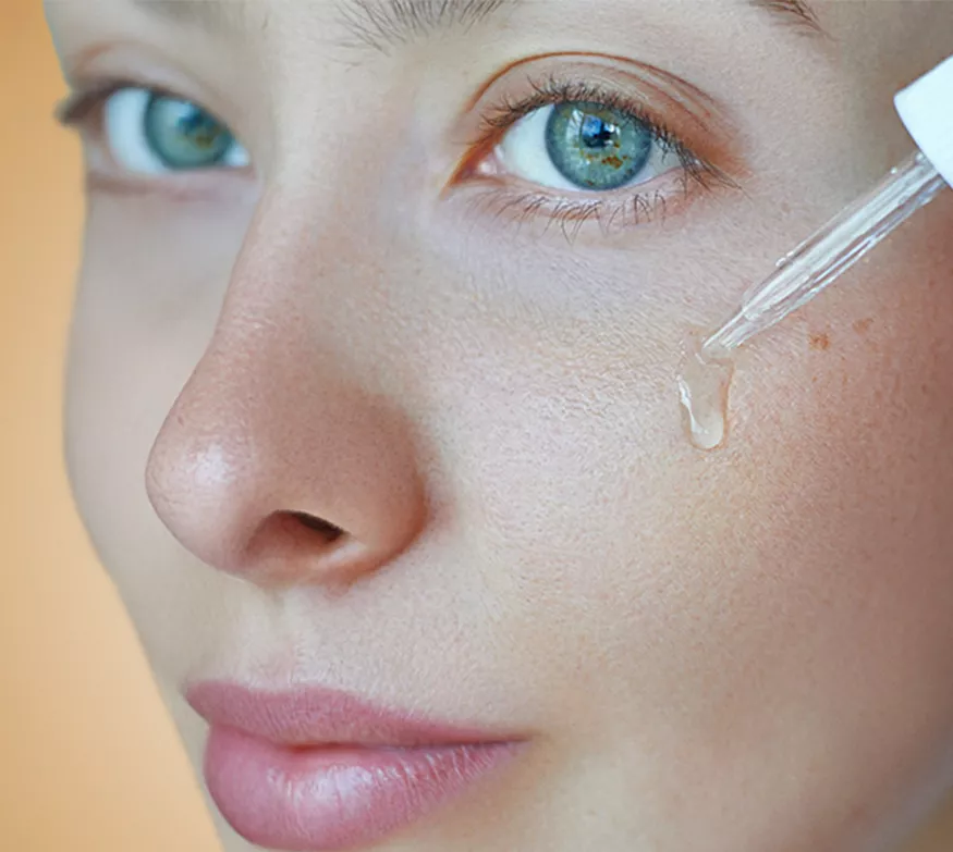 li woman applying facial serum dropper skincare routine